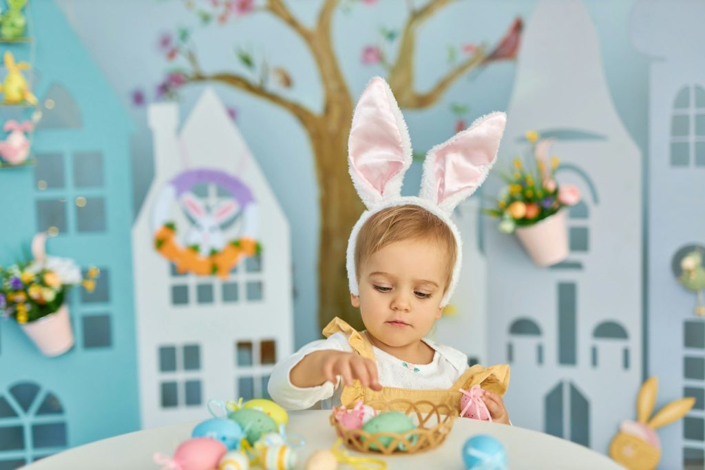Funny cute girl in bunny ears celebrating Easter